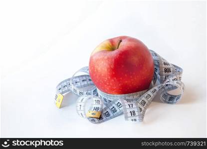 Red Apple and measuring tape on white background. Diet concept. Weight loss. Red Apple and measuring tape on white background. Diet concept