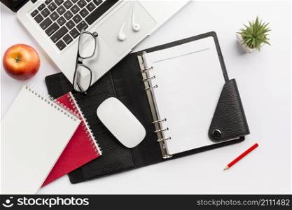 red apple diary mouse eyeglasses earphones pencil laptop white desk
