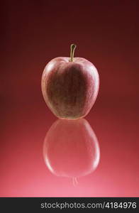 Red apple on reflective background