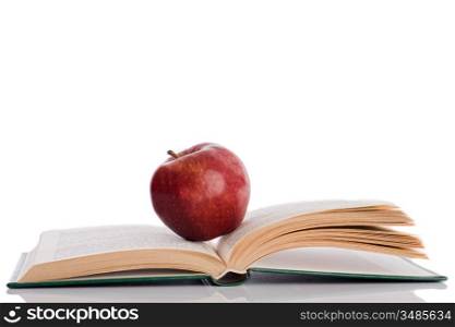 Red apple with open book and reflection on the floor