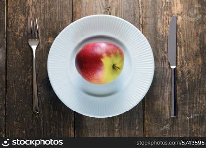 red apples in a blue bowl on wooden background