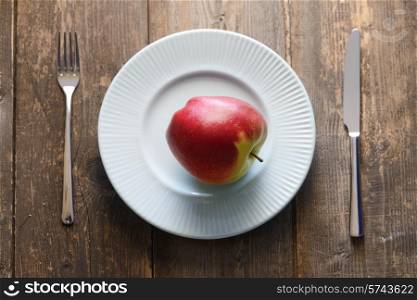 red apples in a blue bowl on wooden background