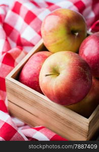 Red apples in a wooden basket, selective focus