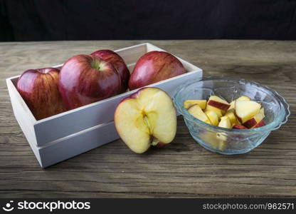 Red apples in the bowl and Apples in the box on the wooden table