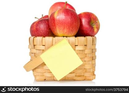 Red apples in woven basket with sticky note. Isolated on the white background