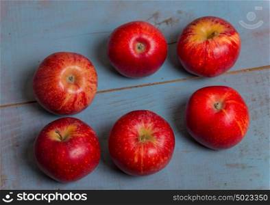 red apples on a old blue wooden table, studio picture