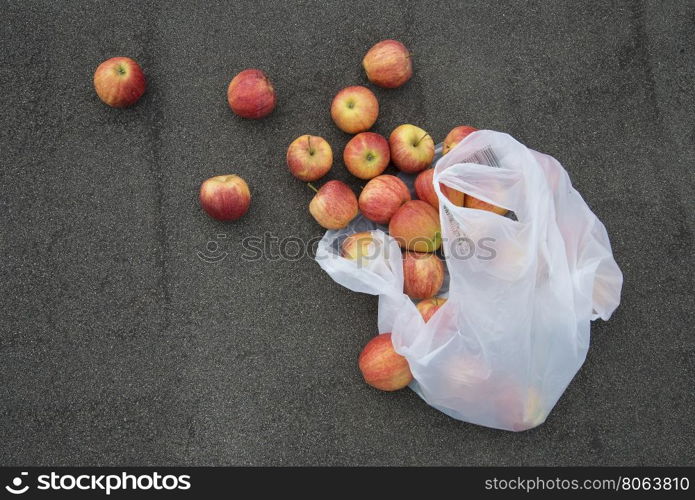 red apples on the pavement. a scattering of red apples on a background of asphalt