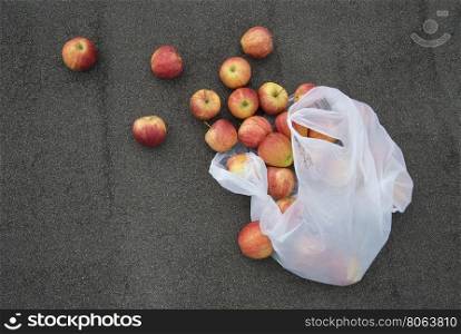 red apples on the pavement. a scattering of red apples on a background of asphalt