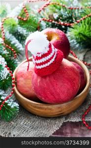 Red apples with hat in bowl, festive decorations, selective focus