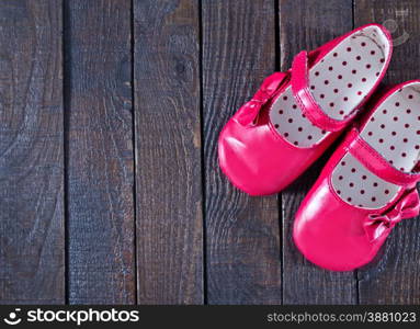 red baby shoes on the wooden background