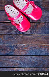 red baby shoes on the wooden background