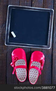 red baby shoes on the wooden background