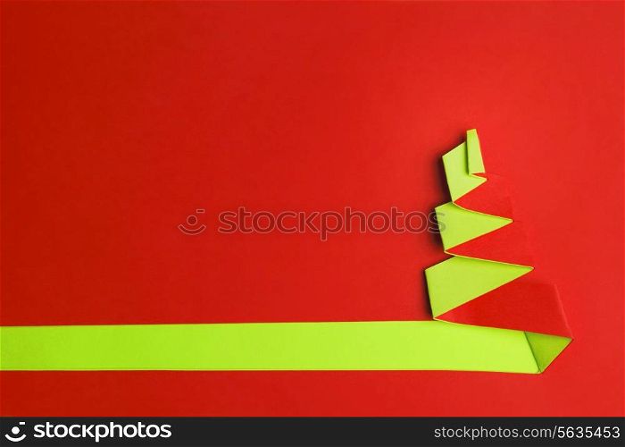 Red background with Conceptual paper christas tree and copy space