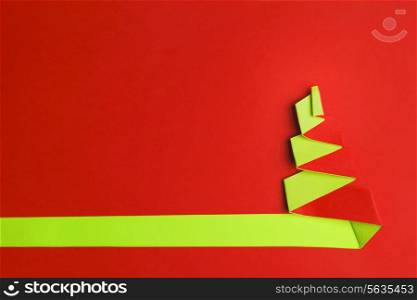 Red background with Conceptual paper christas tree and copy space