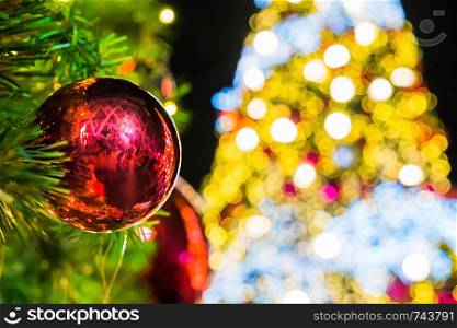Red ball hanging with christmas tree bokeh background