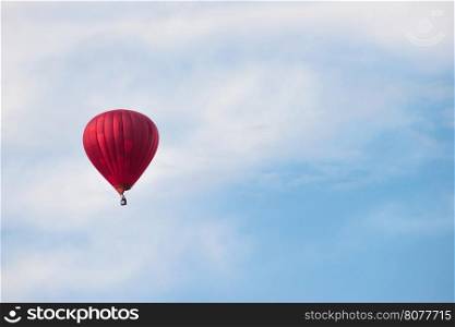Red balloon in the blue cloudy sky