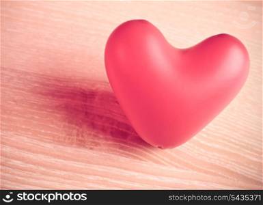 red baloon heart on wooden table, desatureted color