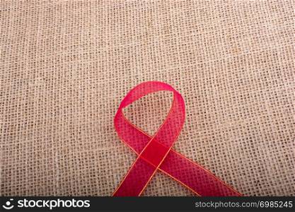 Red band on a brown color linen canvas as a background texture