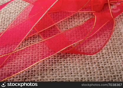 Red band on a brown color linen canvas as a background texture