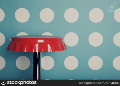 Red bar stool against a background of wall