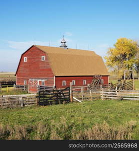 Red barn and fence in field.