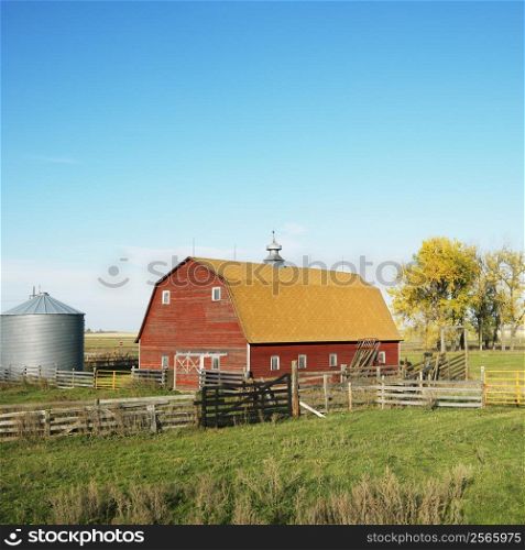 Red barn and fence in field.