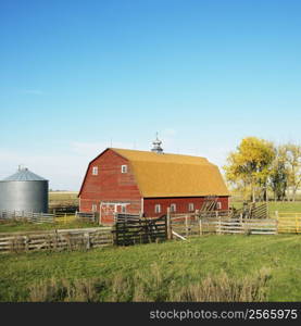 Red barn and fence in field.