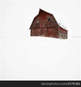 Red barn in winter landscape.