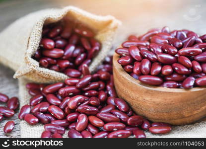 Red bean in wooden bowl on sack background / Grains red kidney beans