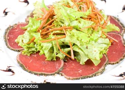red beef sliced meat with greens closeup