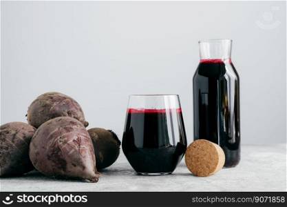 Red beetroot juice in glass containers, fresh beet for making beverage. Vegetable drink. Organic homemade beverage. White background.