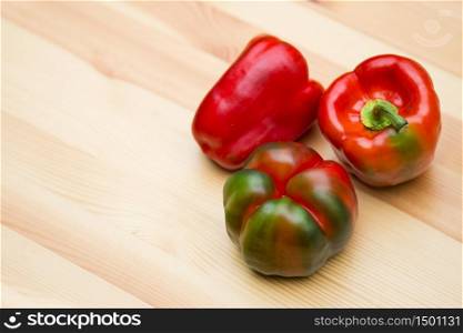 Red bell peppers on wooden table top angle. Red bell peppers