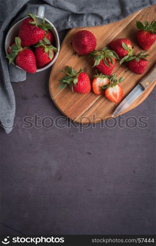Red berry strawberry in ceramic mugs on old concrete background. Background from freshly harvested strawberries