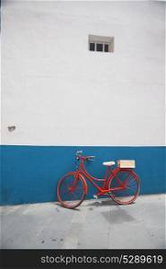 Red bicycle on a white wall background. Red bicycle