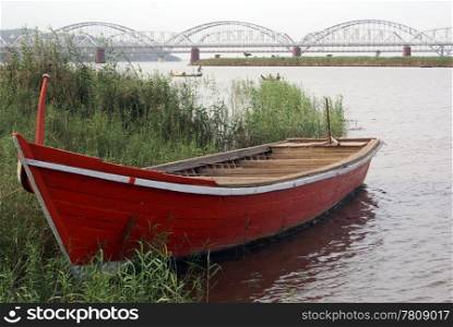 Red boat on the river and bridge