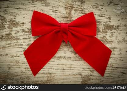 Red bow on a wooden background worn
