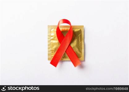 Red bow ribbon symbol HIV, AIDS cancer awareness and condom with shadows, studio shot isolated on white background, Healthcare medicine sexually concept, World AIDS Day
