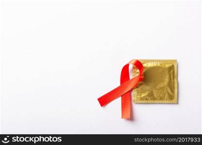 Red bow ribbon symbol HIV, AIDS cancer awareness and condom with shadows, studio shot isolated on white background, Healthcare medicine sexually concept, World AIDS Day