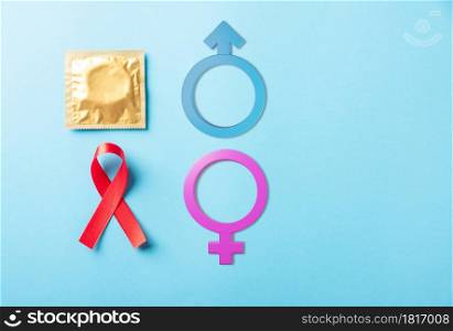Red bow ribbon symbol HIV, AIDS cancer awareness, condom with shadows and Male, female gender signs, studio shot isolated on blue background, Healthcare medicine sexually concept, World AIDS Day