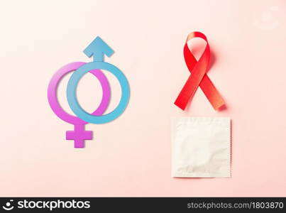 Red bow ribbon symbol HIV, AIDS cancer awareness, Male, female gender signs and condom with shadows, studio shot isolated on pink background, Healthcare medicine sexually concept, World AIDS Day