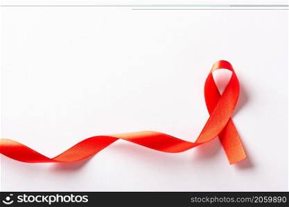 Red bow ribbon symbol HIV, AIDS cancer awareness with shadows, studio shot isolated on white background, Healthcare medicine concept