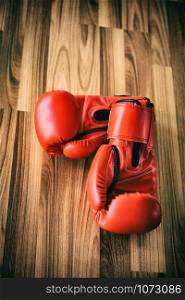 Red boxing gloves on wood background. Sport and healthy lifestyle concept.