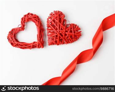 red braided heart and twisted silk ribbon on white background, top view