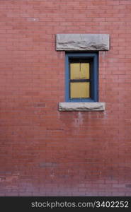 red brick wall and small window with light, sandstone details
