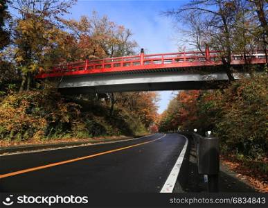 red bridge over an empty road in countryside of Kawaguchiko, Japan