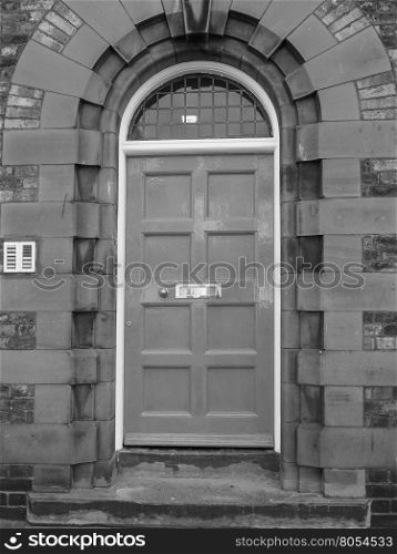 Red British door. Traditional entrance door of a British house in black and white