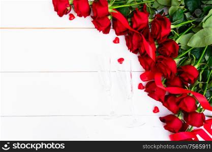 Red buds of valentines day festive roses border on white wooden background with copy space. Red blooming roses on wood