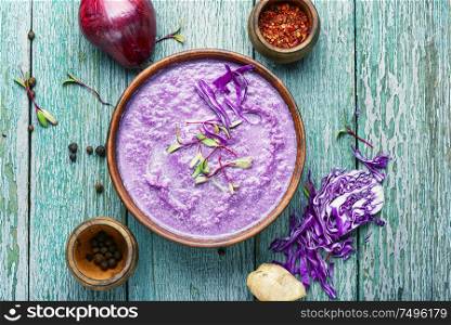Red cabbage soup on old wooden table.Vegetable soup.Autumn cuisine.. Red cabbage soup