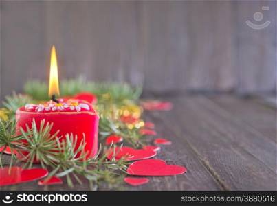 red candle and christmas decoration on the wooden table