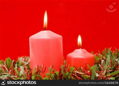 Red candles of Christmas lit on a over red background